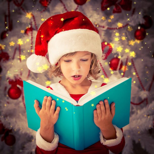 girl in christmas santa hat reading book