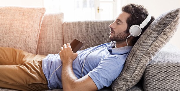 A man lying down with headphones on