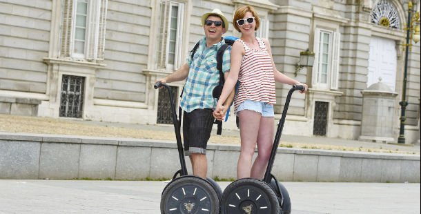 A person and person on two wheeled scooters