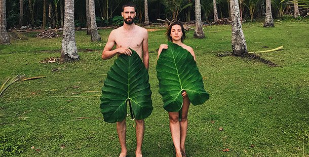A person and person holding large leaves