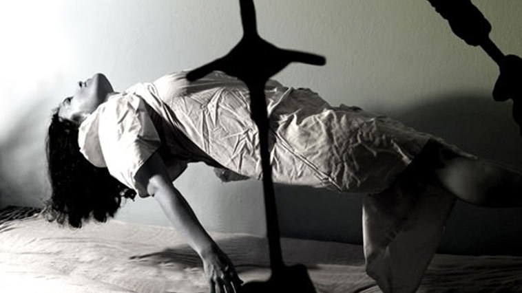 A person doing a handstand on a bed