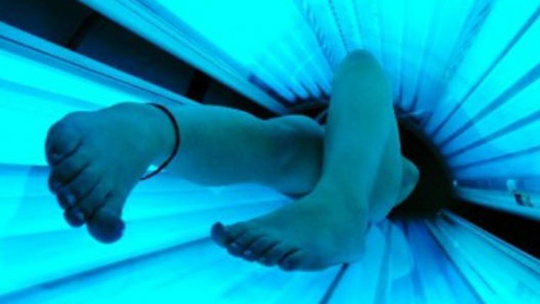 A person lying in a tanning bed