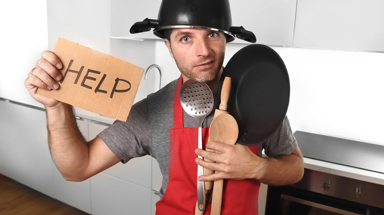 A person in a kitchen holding a pan and a pan