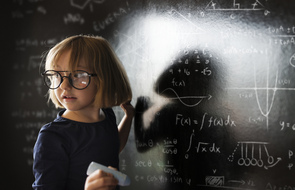 A child standing in front of a blackboard